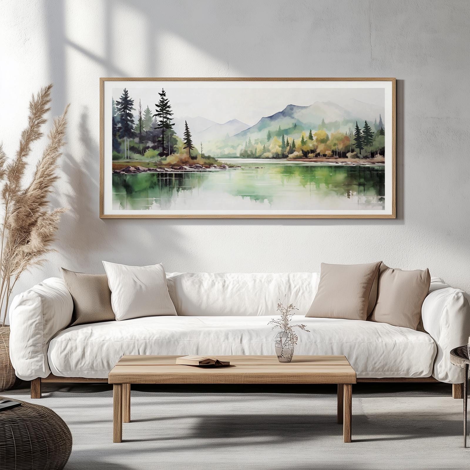 Framed minimalist landscape print centered above a white sofa in a bright room