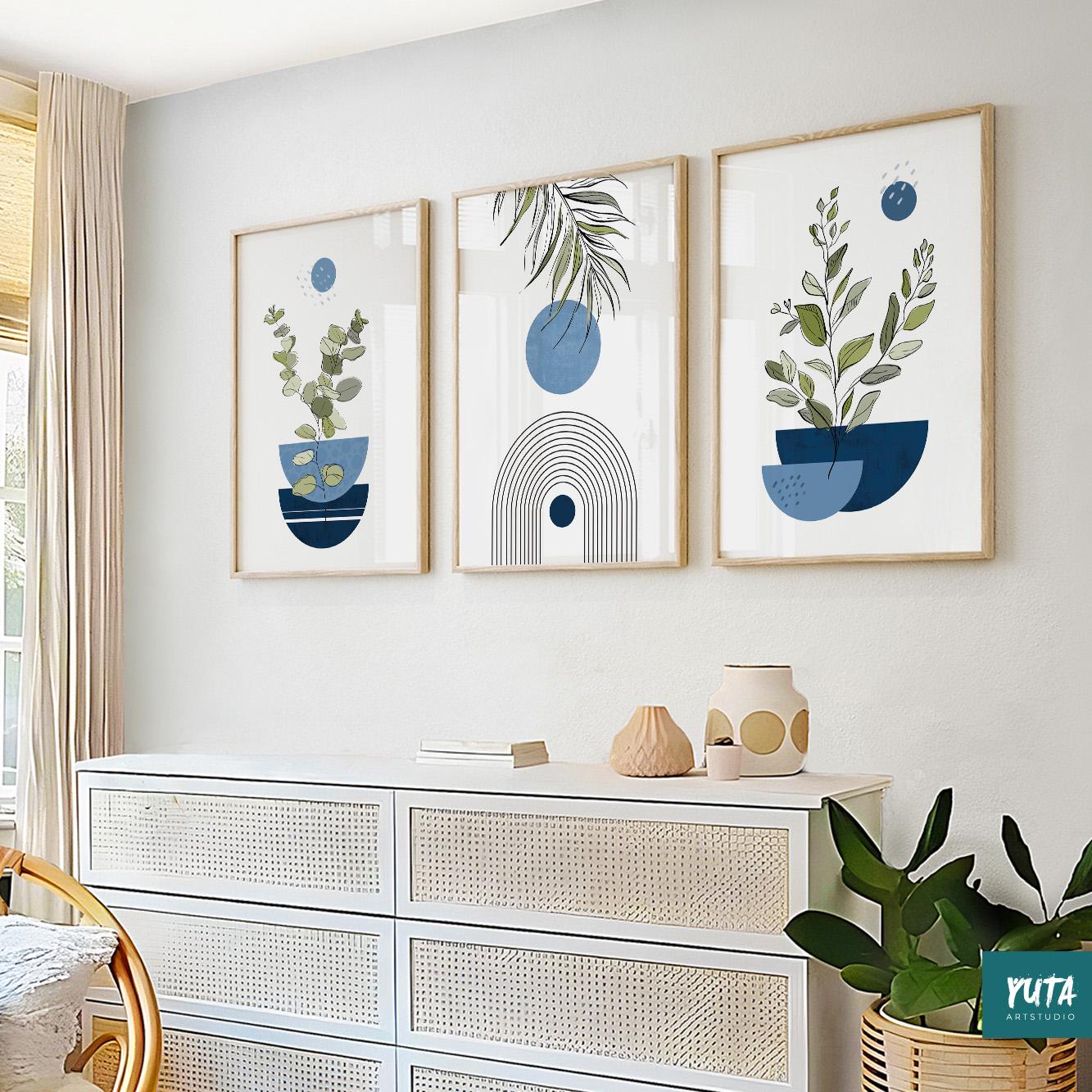 Trio of navy blue abstract botanical art prints in light wood frames above a white dresser