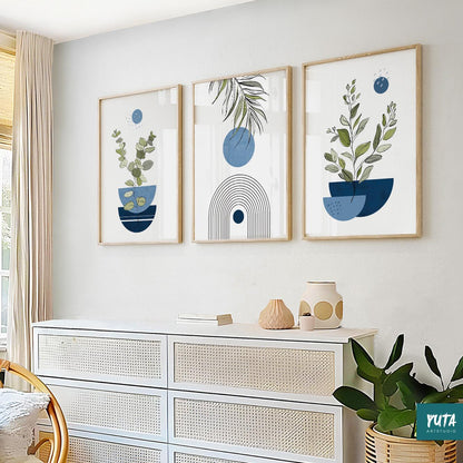 Trio of navy blue abstract botanical art prints in light wood frames above a white dresser