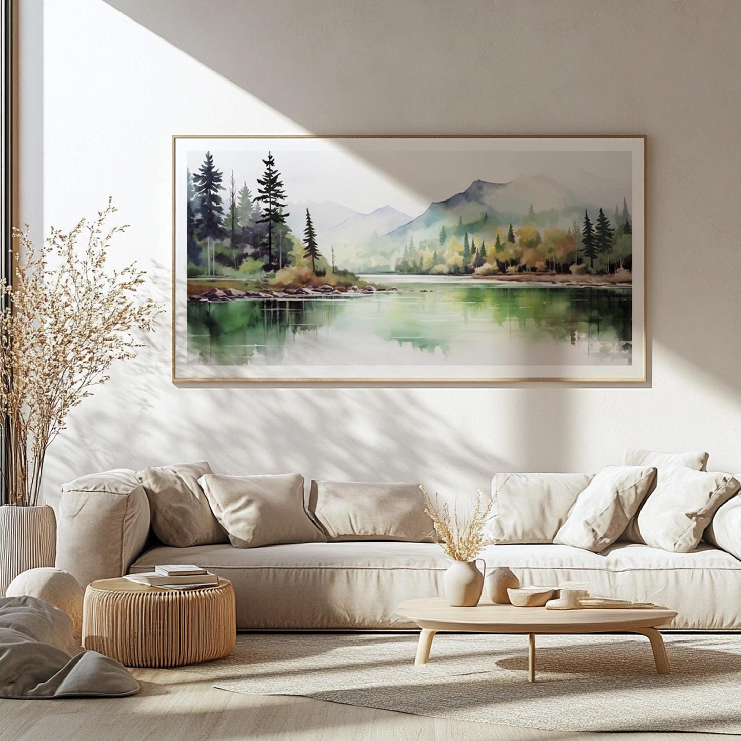 Framed watercolor landscape of forest and lake above neutral sofa in sunlit room