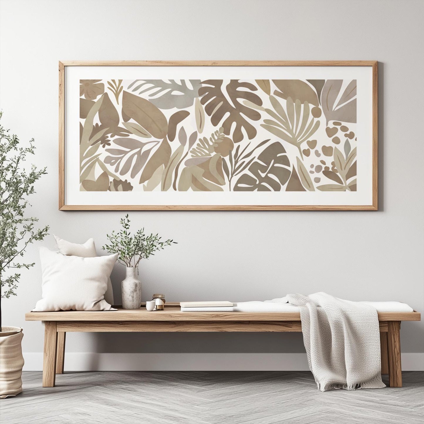 Framed neutral tropical botanical artwork ready for shipment, displayed above a bench.