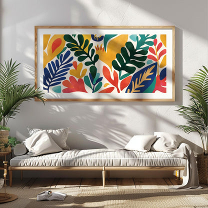 Colorful abstract leaf artwork in a light wood frame displayed above a sunlit daybed