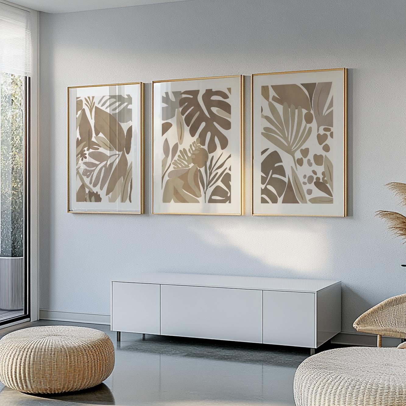 Trio of minimalist mocha tropical prints in gold frames arranged above a white sideboard