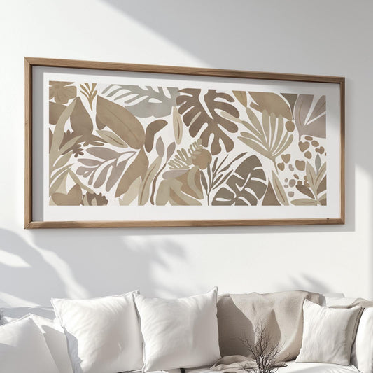 Framed abstract tropical leaf print displayed above a white sofa with cushions