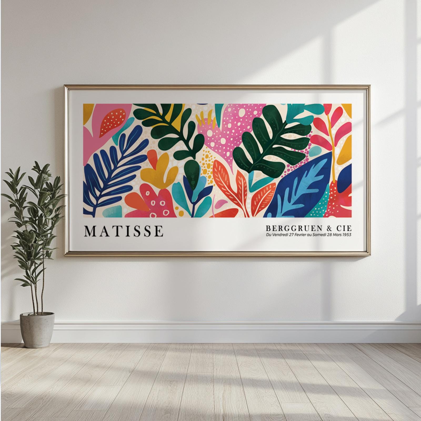 Colorful abstract leaf artwork in a gold frame styled above a console in natural light