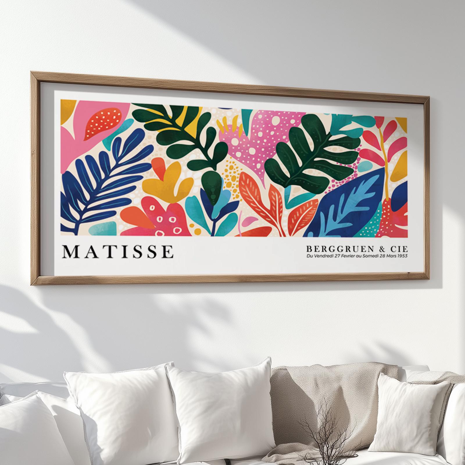 Colorful Matisse-inspired tropical leaf print in a wood frame above a white sofa