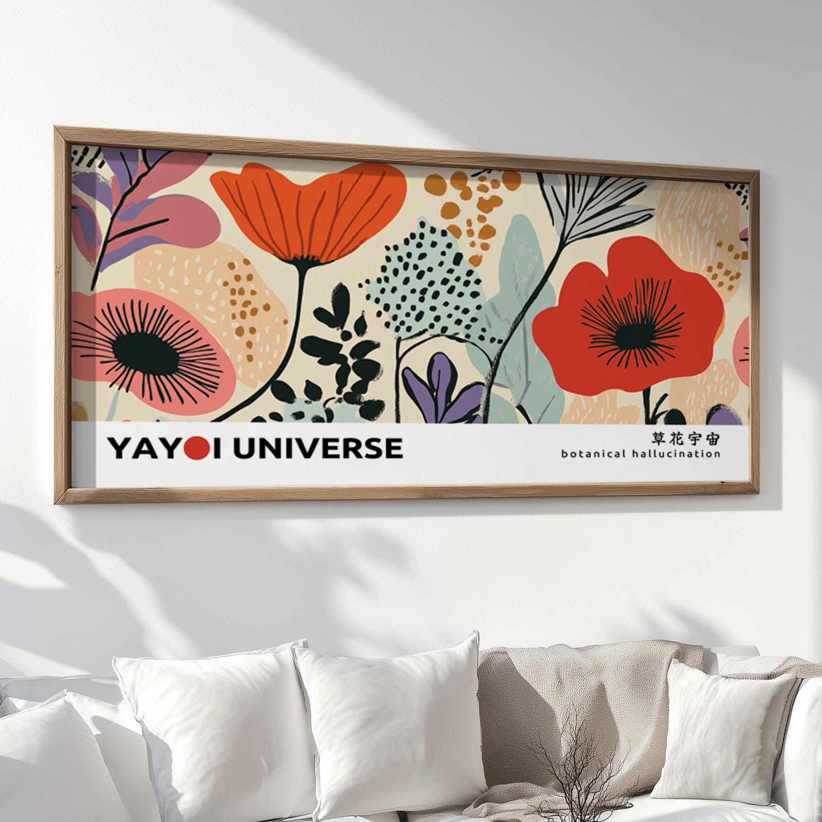 Framed abstract floral art print with bold poppy motifs displayed above a white sofa.