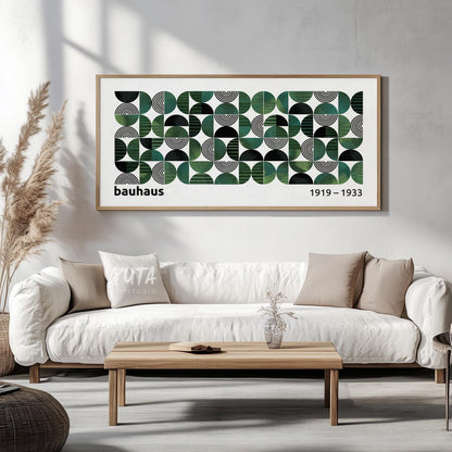 Geometric Bauhaus-inspired print with green and black shapes, framed above a white sofa in soft daylight