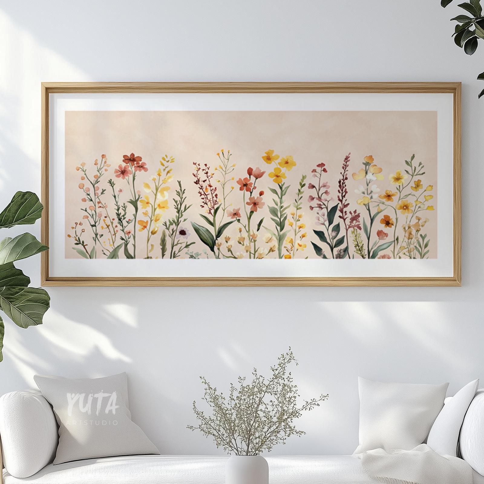 Framed watercolor wildflower art above a white cabinet with minimalist decor