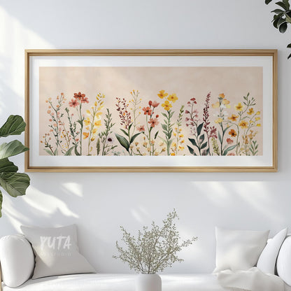 Framed watercolor wildflower art above a white cabinet with minimalist decor