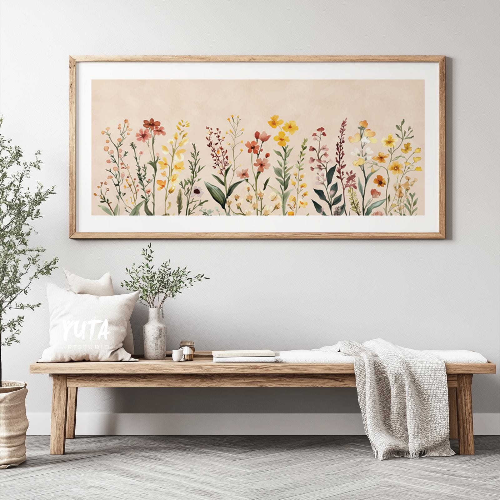 Watercolor wildflowers in soft neutral tones, framed above a wooden bench with decor accents