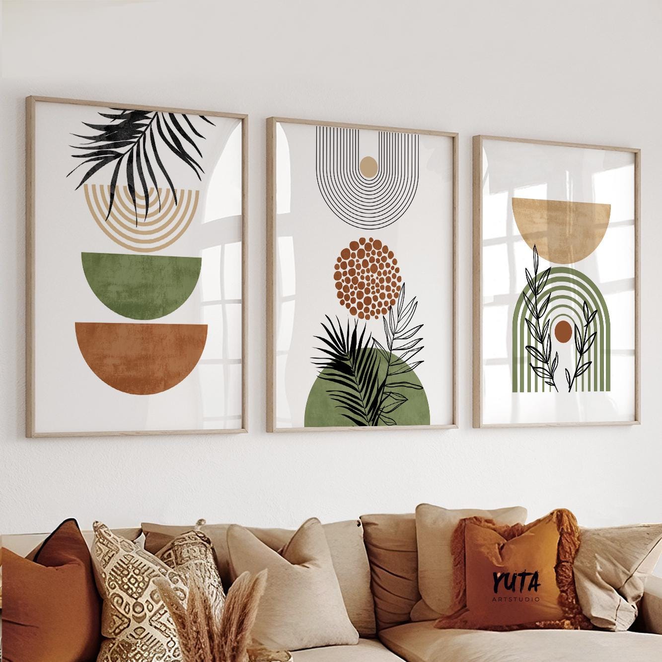Abstract terracotta and green botanical art trio in light wood frames above a neutral sofa