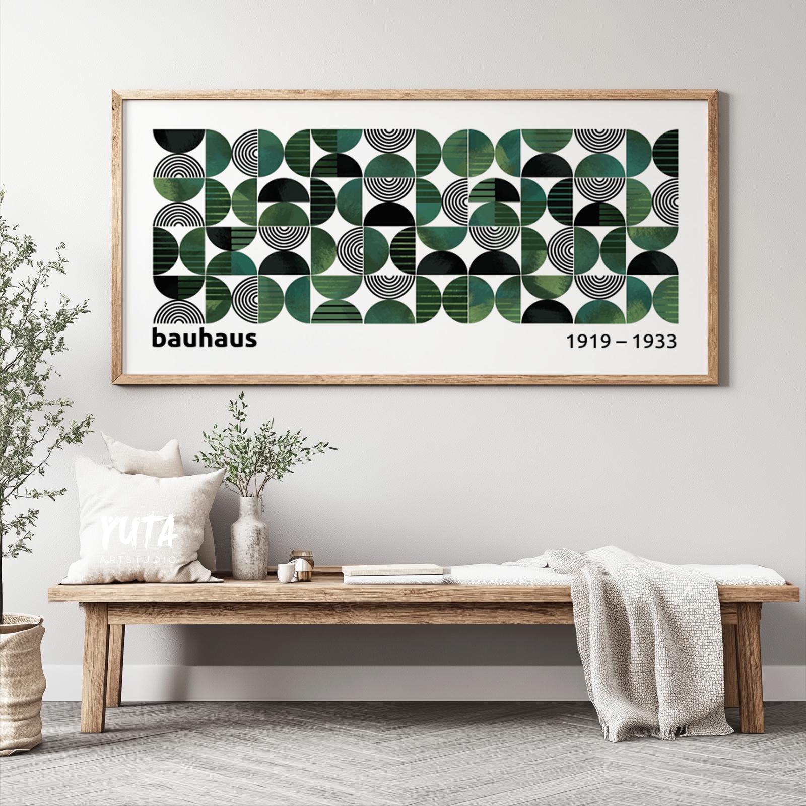 Geometric Bauhaus print in a wooden frame above a bench with books, plants, and ceramics