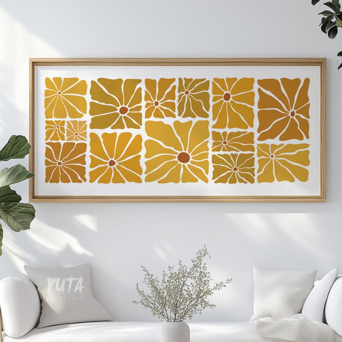Framed retro floral print in mustard and ochre displayed above a white sofa.
