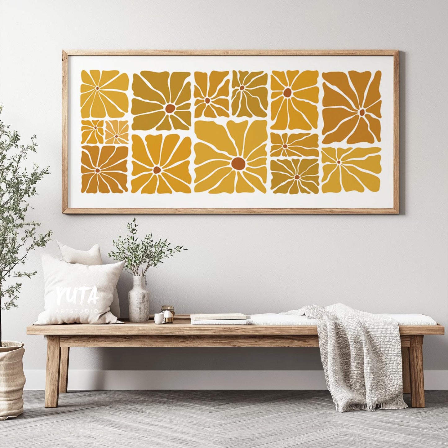 Geometric floral print in mustard hues, framed in wood and centered above a bench.