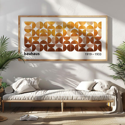Framed Bauhaus geometric print in warm earth tones centered above a minimalist daybed.
