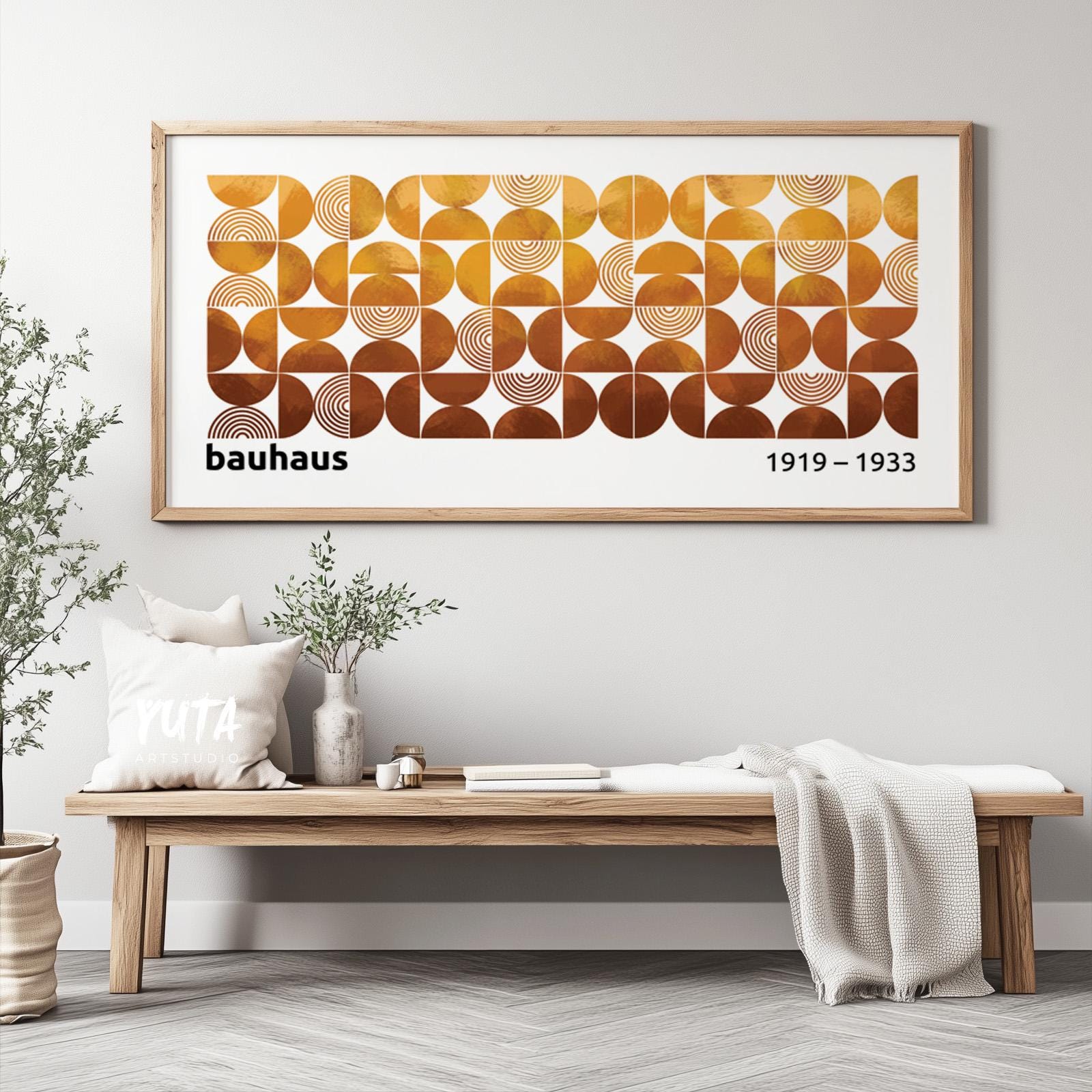 Framed Bauhaus-inspired geometric print in terracotta and mustard tones above a wooden bench