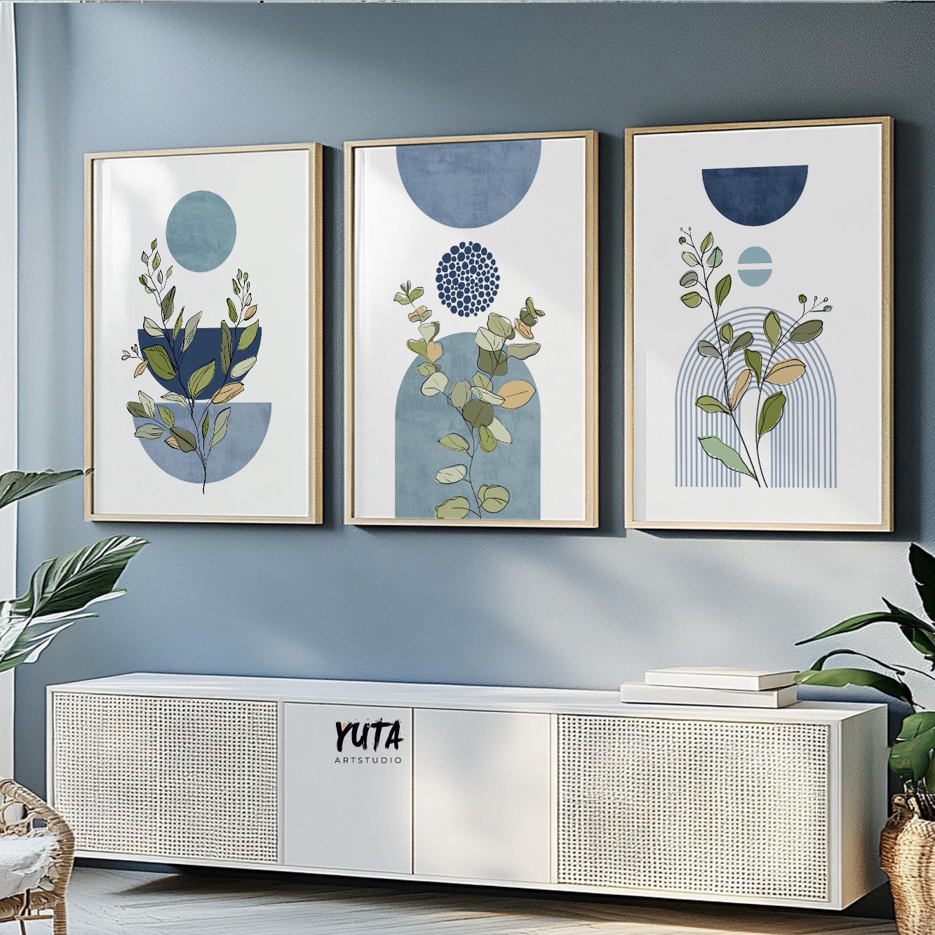 Three framed botanical prints with blue geometric shapes hung above a modern sideboard