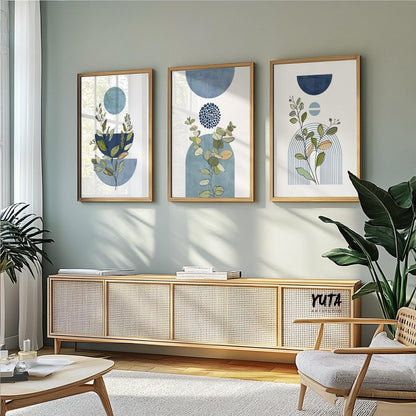 Trio of framed blue botanical geometric prints styled above a natural wood sideboard