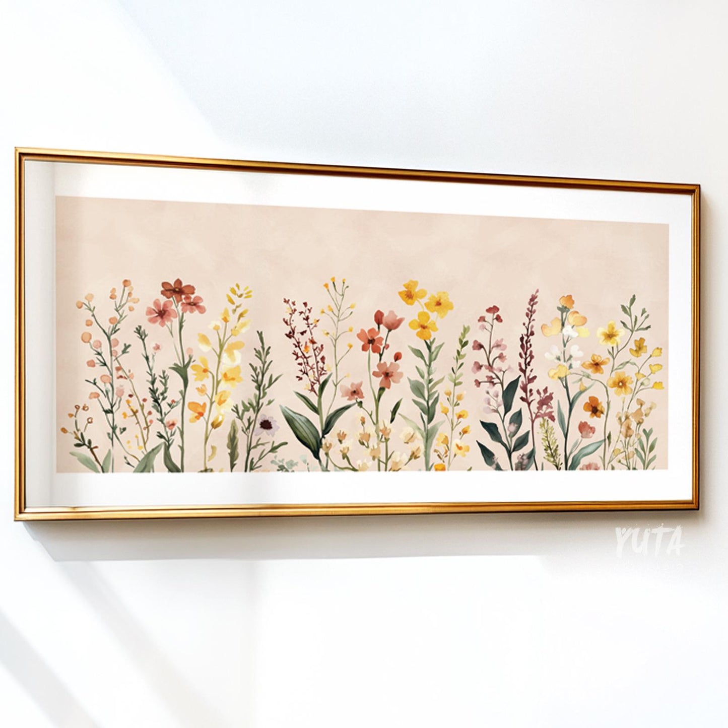 Neutral floral illustration with wildflowers in soft colors, framed in gold on a white wall