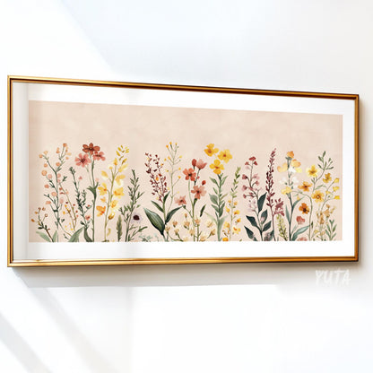 Neutral floral illustration with wildflowers in soft colors, framed in gold on a white wall