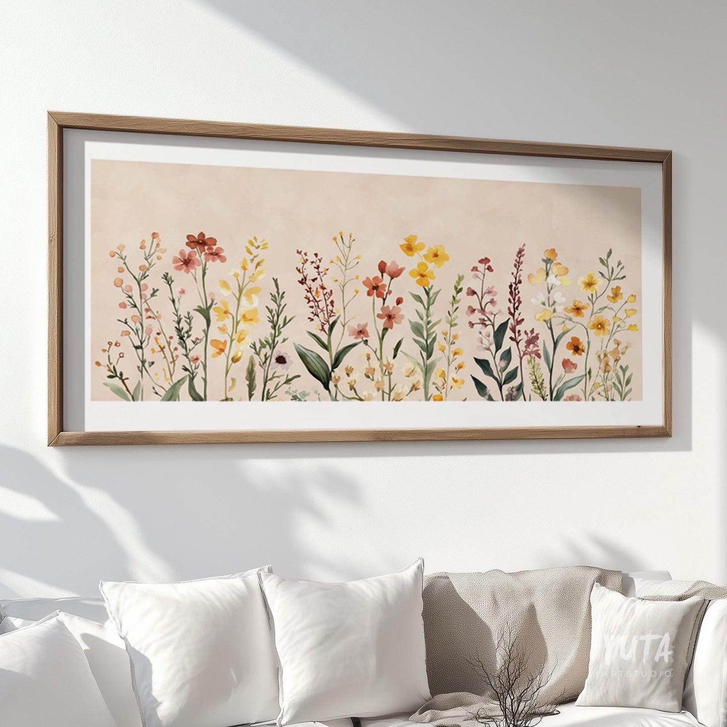 Framed neutral floral print in wide landscape format shown above sofa for size reference