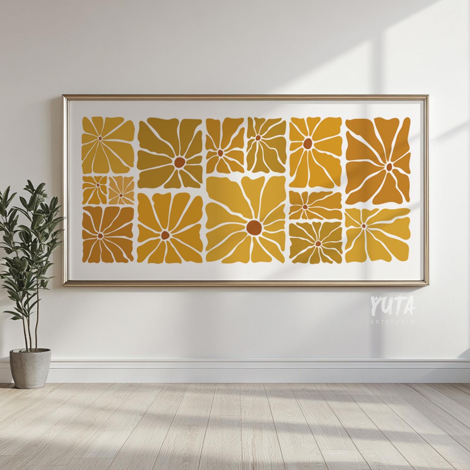 Large framed mid century floral print in mustard tones displayed in sunlight above wood floors