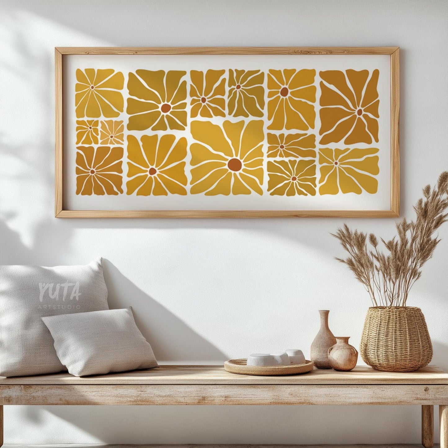 Mid-century floral art in mustard and ochre, framed in wood, above a bench.