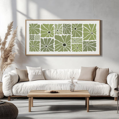 Olive green retro floral print in a natural wood frame, displayed above a white sofa.