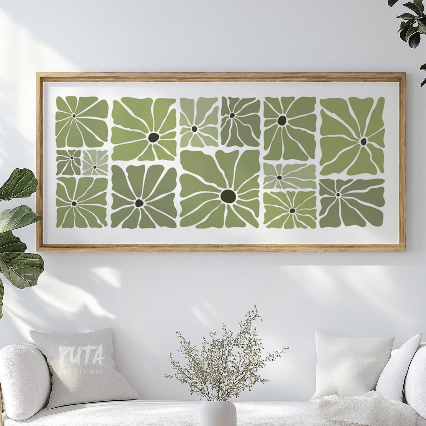 Olive green mid-century floral print in a light wood frame displayed above a white sofa