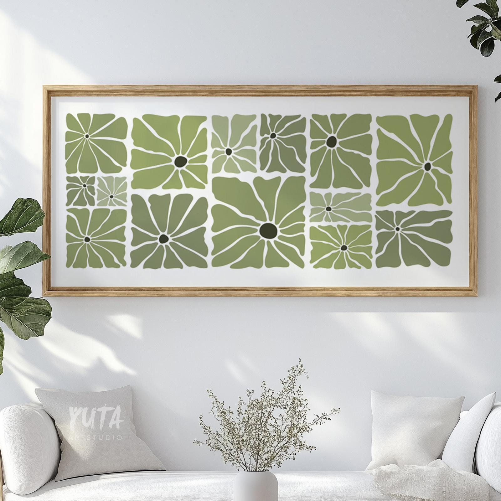Olive green mid-century floral print in a light wood frame displayed above a white sofa