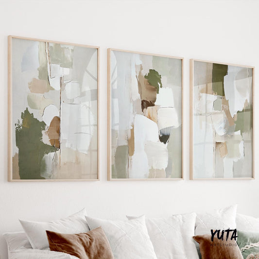 Three framed abstract prints in olive green and beige hung above a sofa in daylight