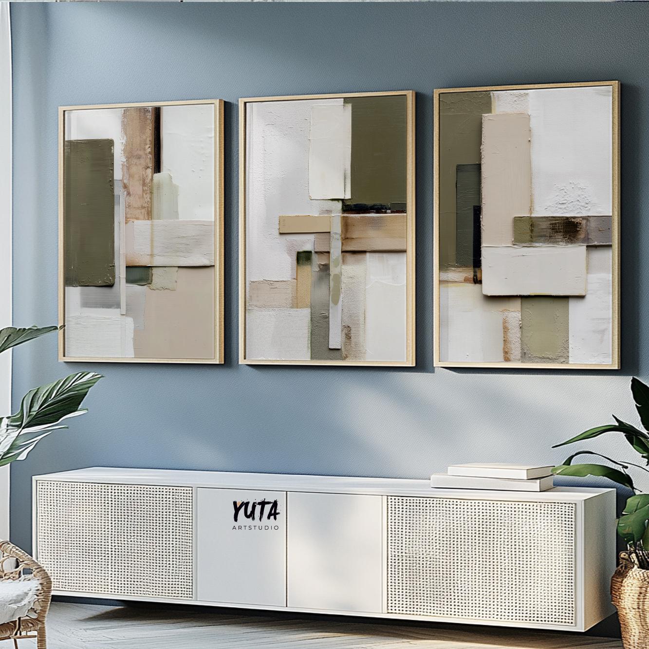 Neutral abstract triptych with olive and beige geometric forms in light wood frames above a white console.