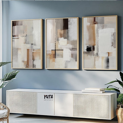 Three neutral abstract canvas prints framed and displayed above a console, ready to ship.