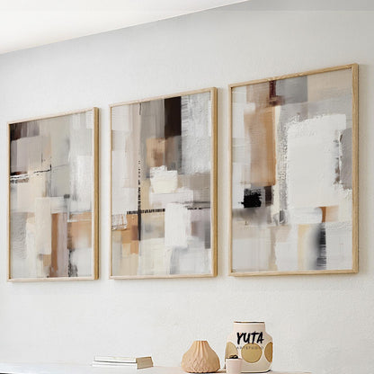 Three neutral abstract prints in light wood frames arranged as a modern gallery set.