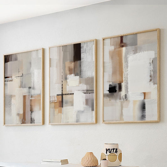 Three neutral abstract prints in light wood frames arranged as a modern gallery set.
