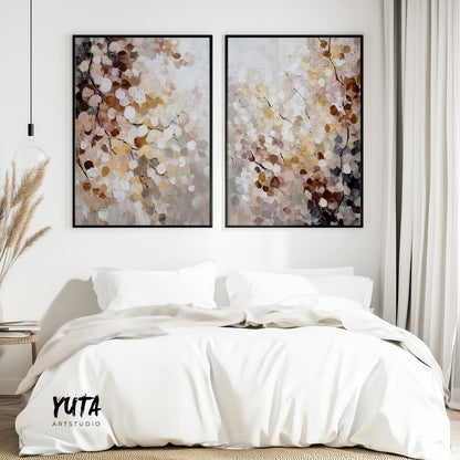 Two framed abstract botanical artworks with layered neutral blossoms above a bed
