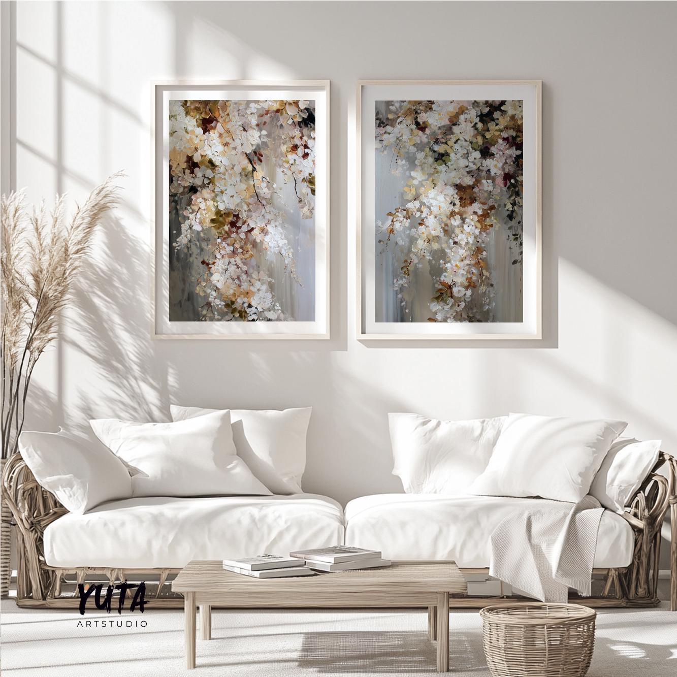 Two framed abstract floral artworks displayed as a pair above a light wood coffee table styled with books and pampas grass.