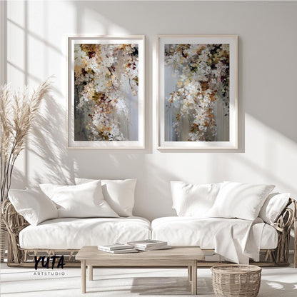 Two framed abstract floral artworks displayed as a pair above a light wood coffee table styled with books and pampas grass.