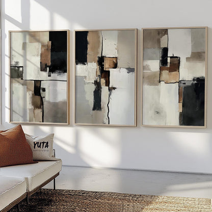 Set of three framed abstract paintings arranged above a neutral sofa and woven rug
