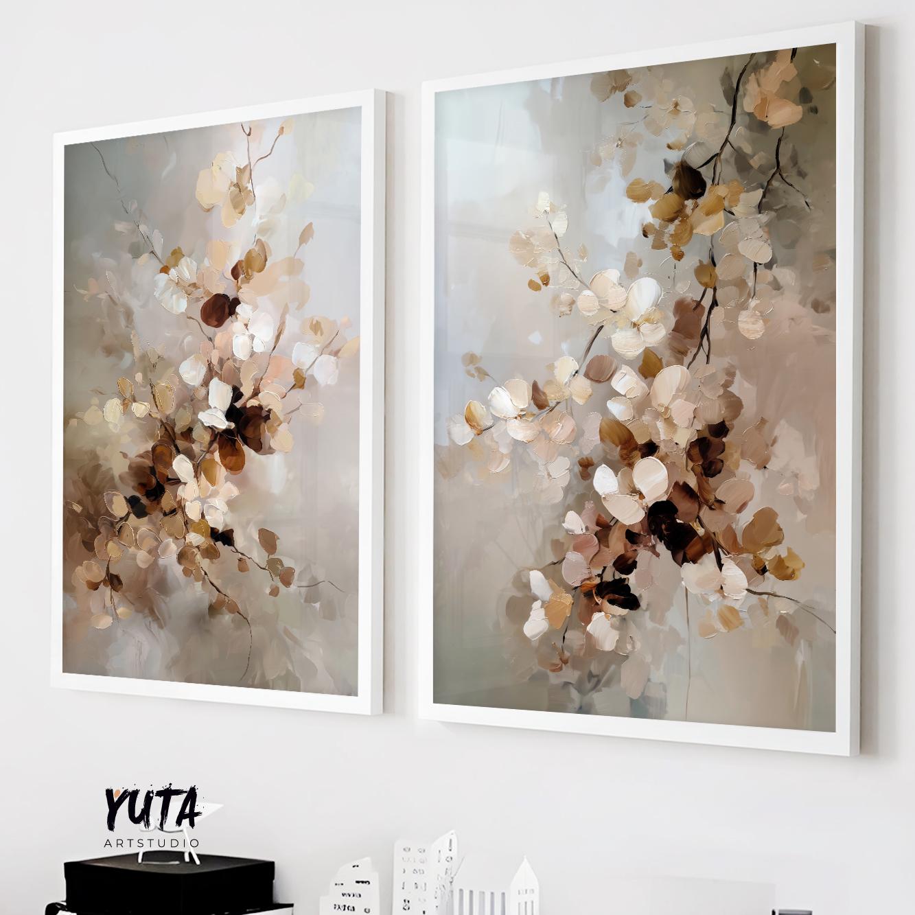 Two abstract neutral floral prints in white frames displayed above stacked books and ceramics