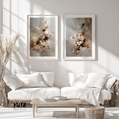 Two framed abstract floral prints in soft beige tones above white seating in sunlit room