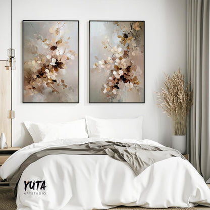 Two framed neutral botanical prints above a bed, styled with dried grasses and books.