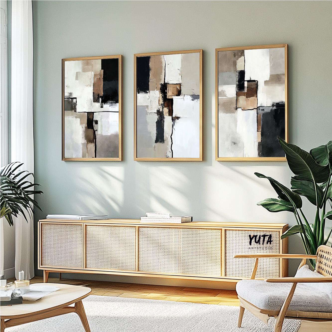 Three neutral abstract paintings with textured block patterns in natural wood frames above a console