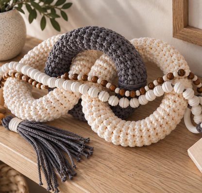 Neutral shelf decor with three interlocking cotton rings in gray and beige with natural wood bead details