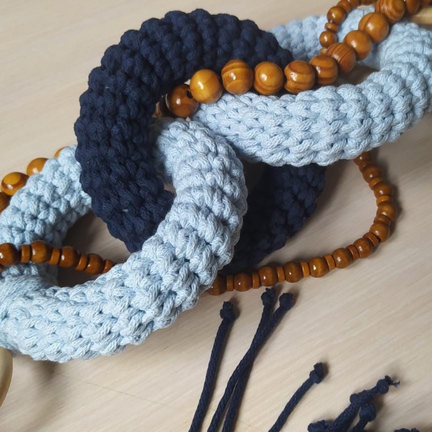 Close up of handmade macrame decor with blue woven cord and wooden beads