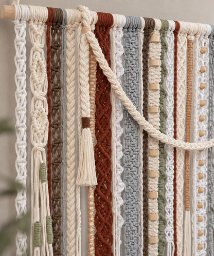 Close up of cream rust olive and gray woven cords in a textured wall hanging
