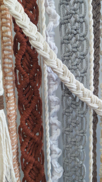Close up of rust cream and gray woven textures on handmade macrame wall art