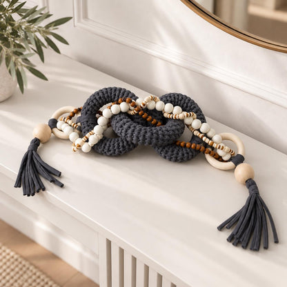 Coffee table decor featuring charcoal gray textile links, wood beads and white bead strands