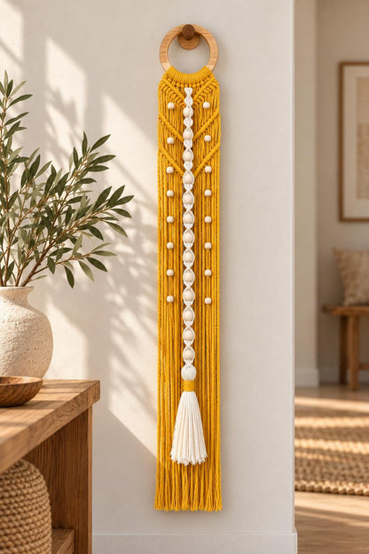 Yellow handmade macrame wall hanging with natural wooden beads and decorative ivory tassel